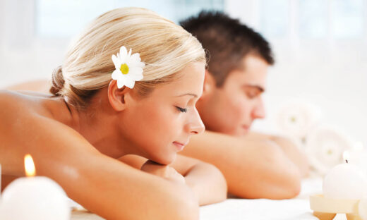 A beautiful couple relaxing themselves at the spa centre with their eyes closed. White background.
