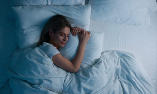 Woman sleeping in bed at night, above view. Space for text