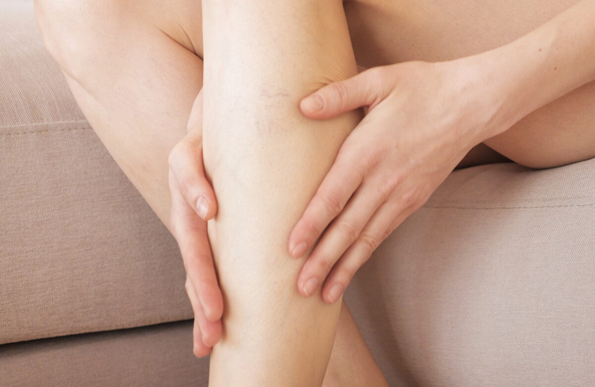 A young girl massages her thin and long tired legs at home after long working day. Prevention of varicose veins.