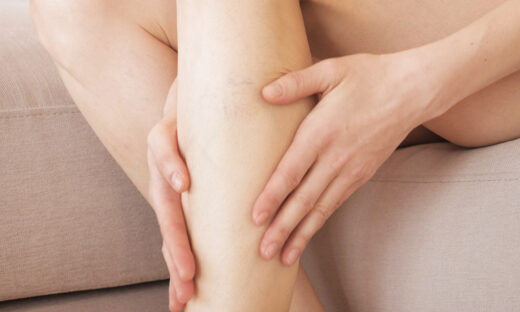 A young girl massages her thin and long tired legs at home after long working day. Prevention of varicose veins.