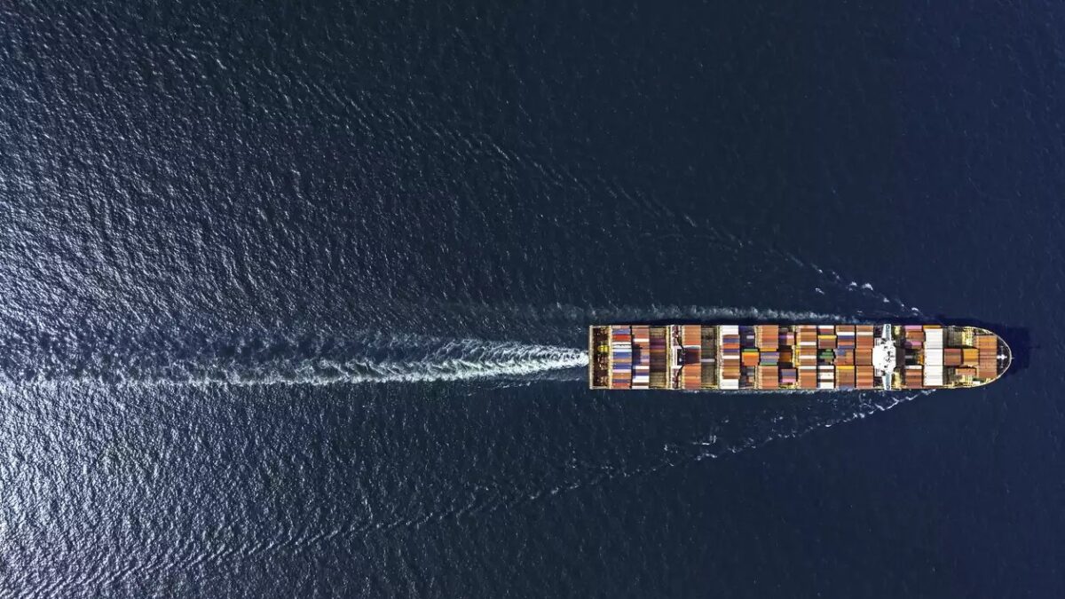 Aerial top view container ship in export and import business and logistics. Shipping cargo to harbor by crane.