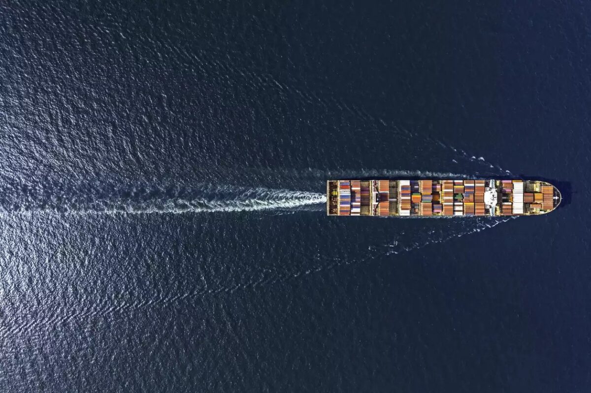 Aerial top view container ship in export and import business and logistics. Shipping cargo to harbor by crane.