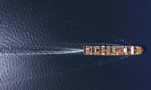 Aerial top view container ship in export and import business and logistics. Shipping cargo to harbor by crane.