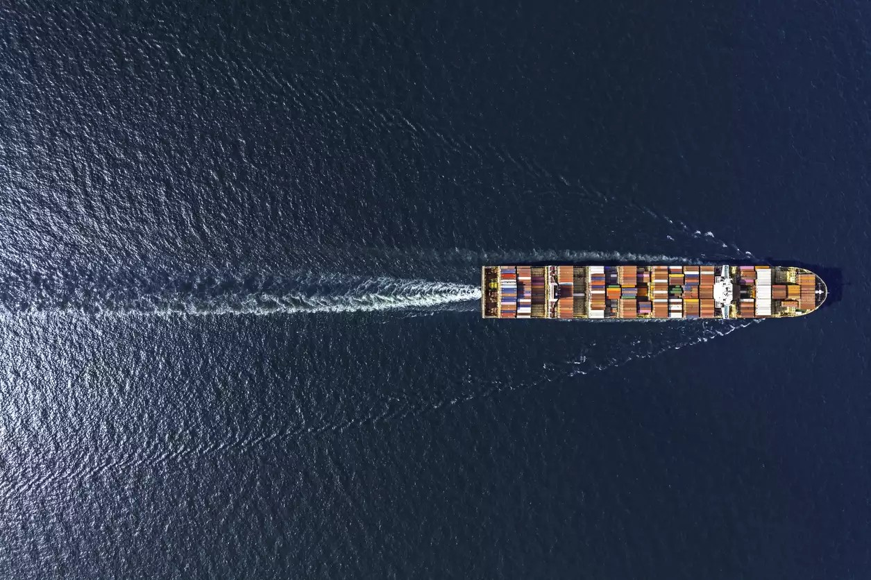 Aerial top view container ship in export and import business and logistics. Shipping cargo to harbor by crane.