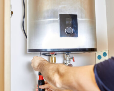 the man tightens the pipe nut in the water heating system