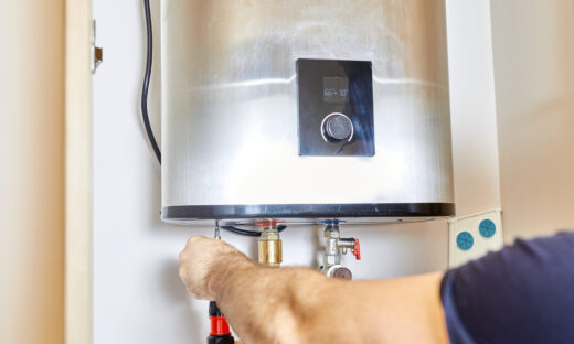 the man tightens the pipe nut in the water heating system