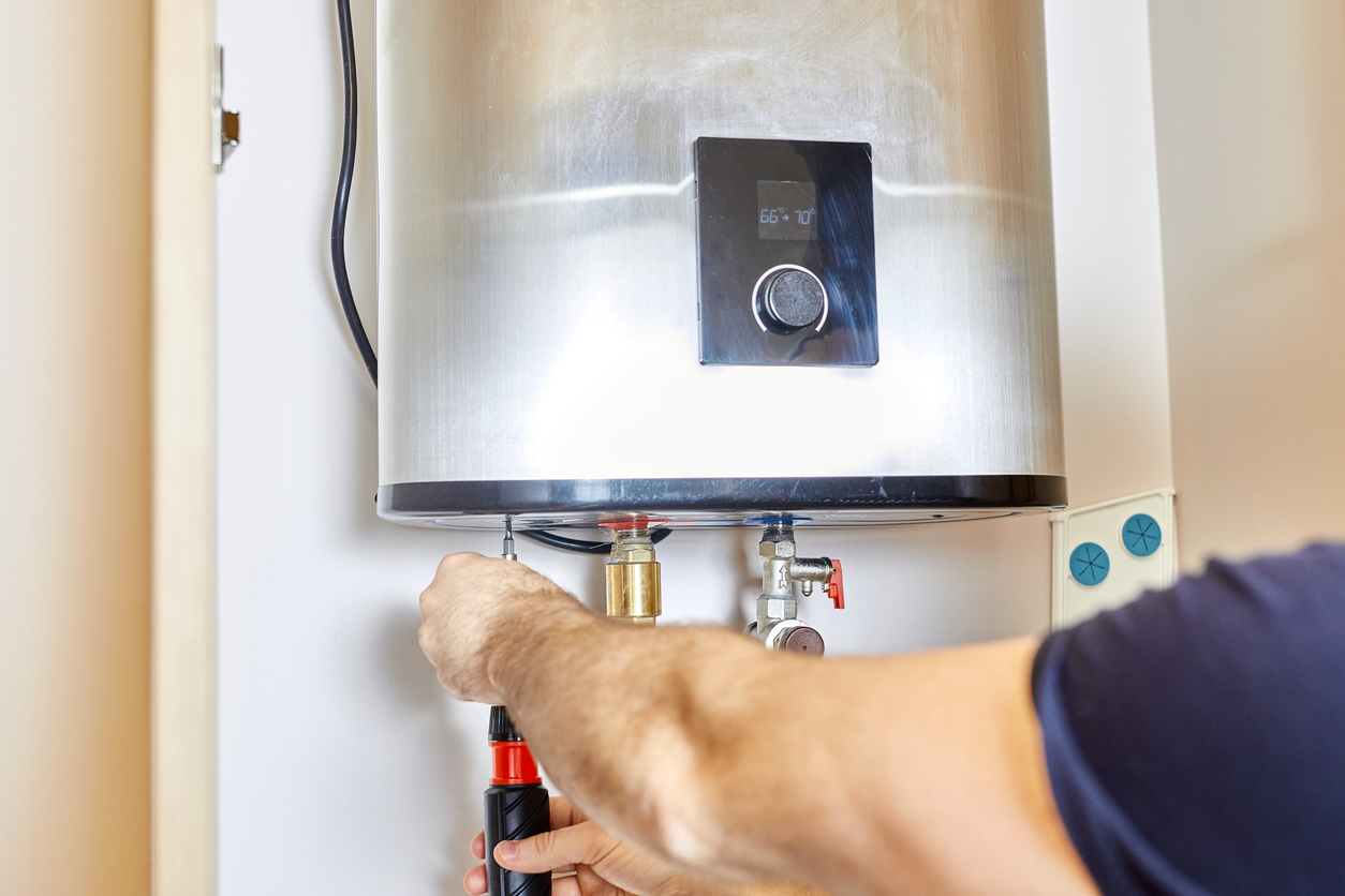the man tightens the pipe nut in the water heating system