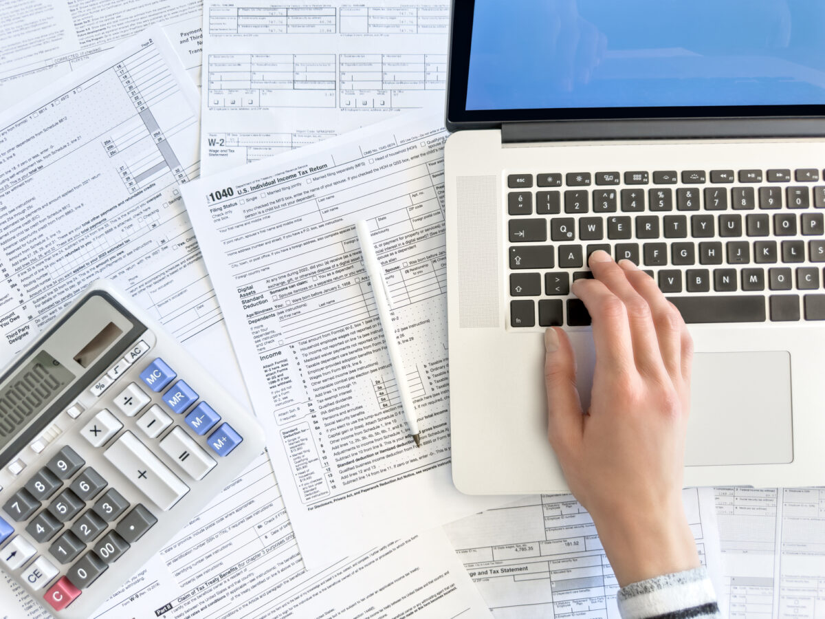 Doing taxes with laptop and tax forms in a house