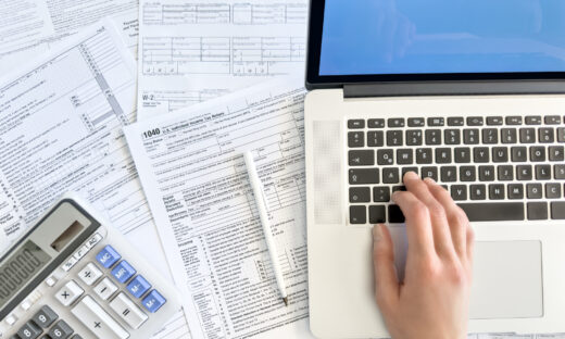 Doing taxes with laptop and tax forms in a house