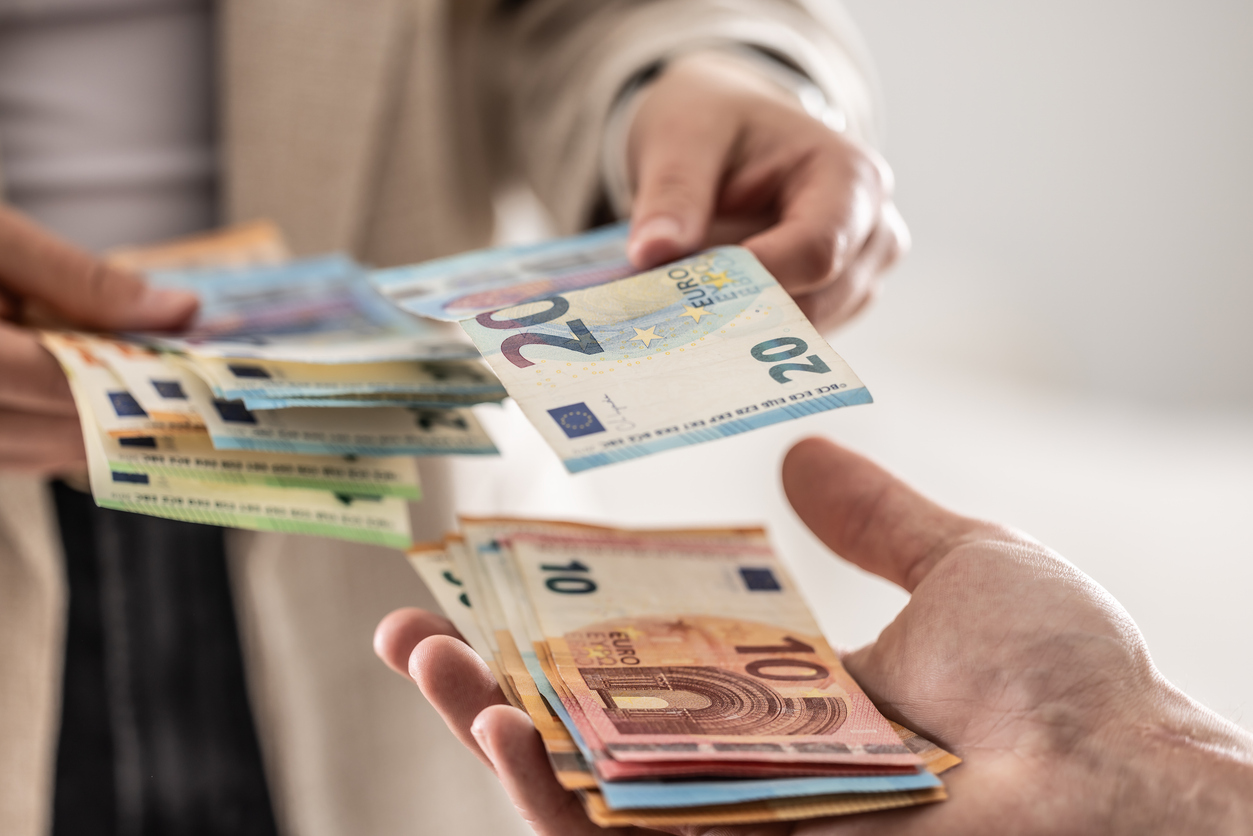 Businesswoman's hands exchanging euro banknotes