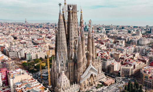 Aerial view of Sagrada Familia Cathedral in Barcelona, Catalonia, Spain, Aerial view of Barcelona Eixample residential area and Sagrada Familia Basilica, most famous travel destinations in europe The Basílica i Temple Expiatori de la Sagrada Família, otherwise known as Sagrada Família, is a church under construction in the Eixample district of Barcelona, Catalonia, Spain. It is the largest unfinished Catholic church in the world. Designed by Catalan architect Antoni Gaudí (1852–1926), his work on Sagrada Família is part of a UNESCO World Heritage Site. On 7 November 2010, Pope Benedict XVI consecrated the church and proclaimed it a minor basilica. On 19 March 1882, construction of the Sagrada Família began under architect Francisco de Paula del Villar. In 1883, when Villar resigned, Gaudí took over as chief architect, transforming the project with his architectural and engineering style, combining Gothic and curvilinear Art Nouveau forms. Gaudí devoted the remainder of his life to the project, and he is buried in the church's crypt. At the time of his death in 1926, less than a quarter of the project was complete.