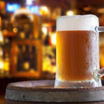 Cold mug of beer in a bar on wooden barrel