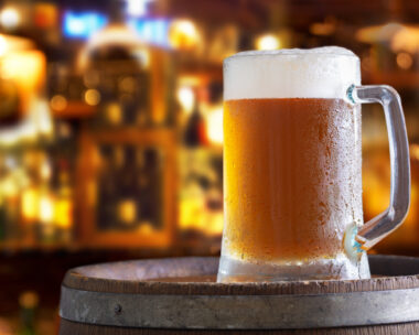 Cold mug of beer in a bar on wooden barrel