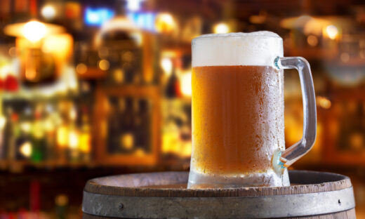 Cold mug of beer in a bar on wooden barrel