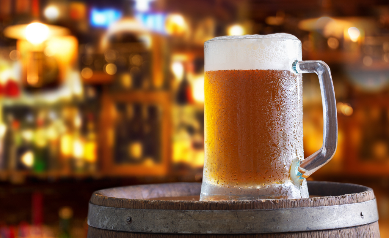 Cold mug of beer in a bar on wooden barrel