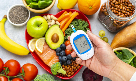 Hand holding glucometer on healthy food background. High resolution 42Mp studio digital capture taken with SONY A7rII and Zeiss Batis 40mm F2.0 CF lens