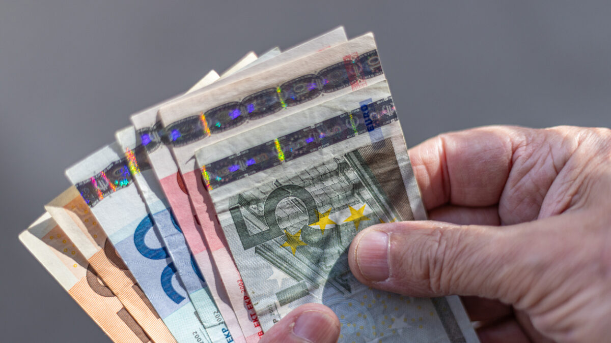 Close-up of a fan of Euro banknotes held on a man's hands