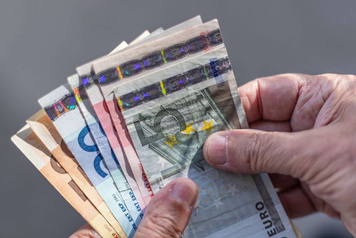 Close-up of a fan of Euro banknotes held on a man's hands
