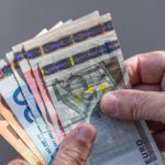 Close-up of a fan of Euro banknotes held on a man's hands