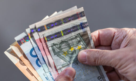 Close-up of a fan of Euro banknotes held on a man's hands