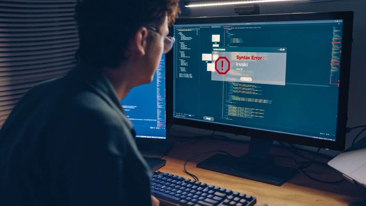 Tired white man programmer or IT specialist software developer works on debugging code warning Error System failure when the code contains a violation of the programming language's rules solving during code validation