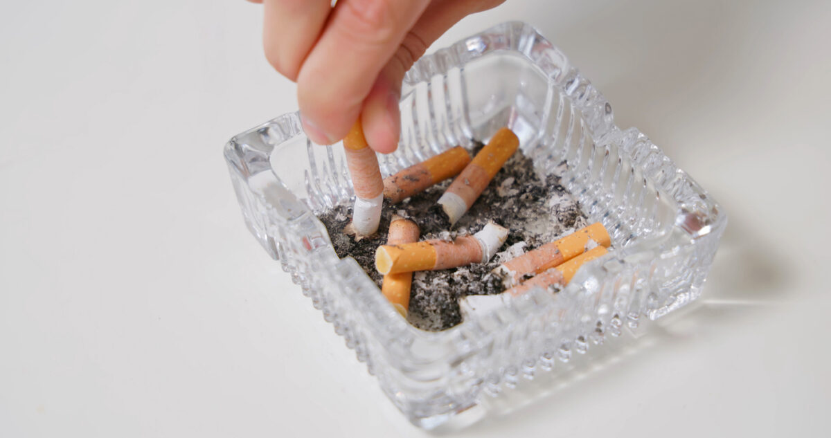 Top view of human hand putting out cigarette - a quitting smoking concept