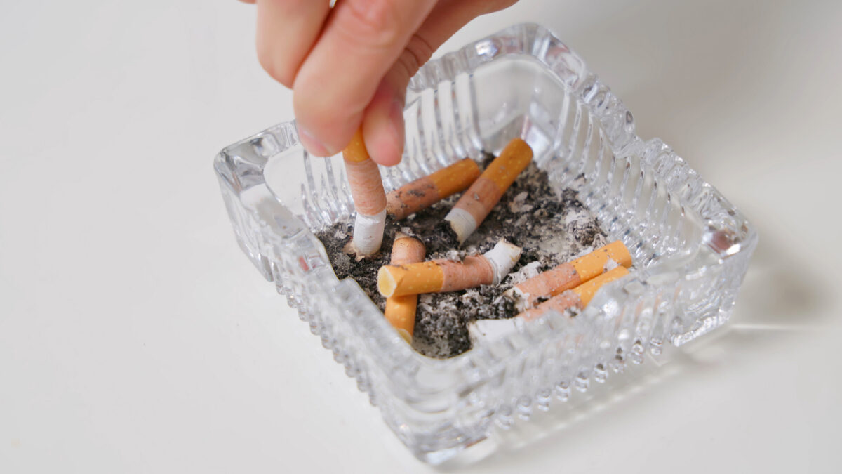 Top view of human hand putting out cigarette - a quitting smoking concept