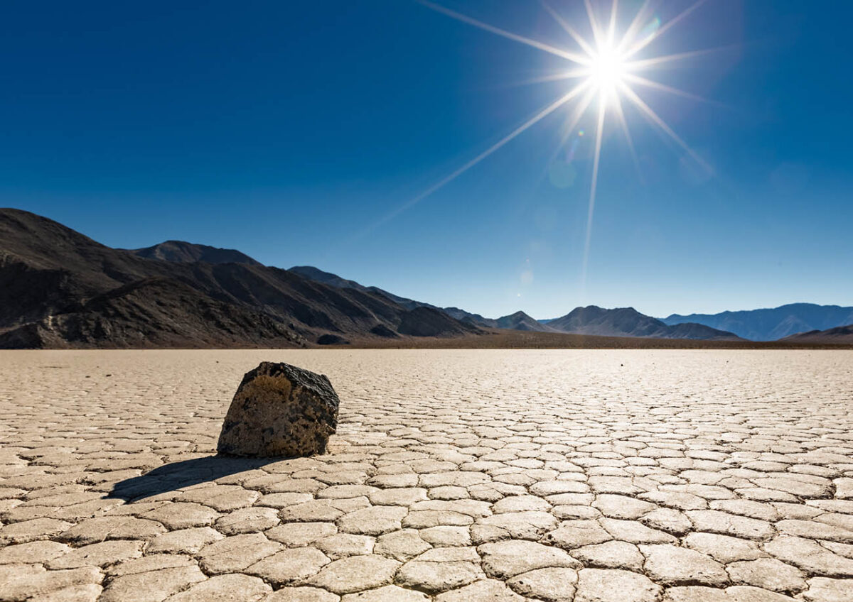 A lone "sailing rock" sits basking in the bright unrelenting sun at Racetrack Playa in Death Valley National Park, California