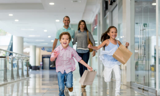 Happy Latin American family shopping and running towards the camera at the mall - lifestyle concepts
