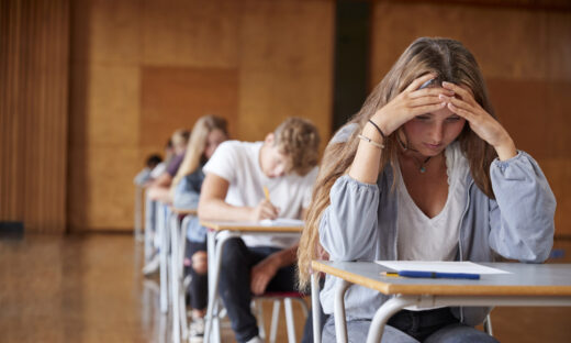 Anxious Teenage Student Sitting Examination In School Hall