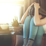 Ένα κορίτσι καθισμένο κρύβει το πρόσωπό του