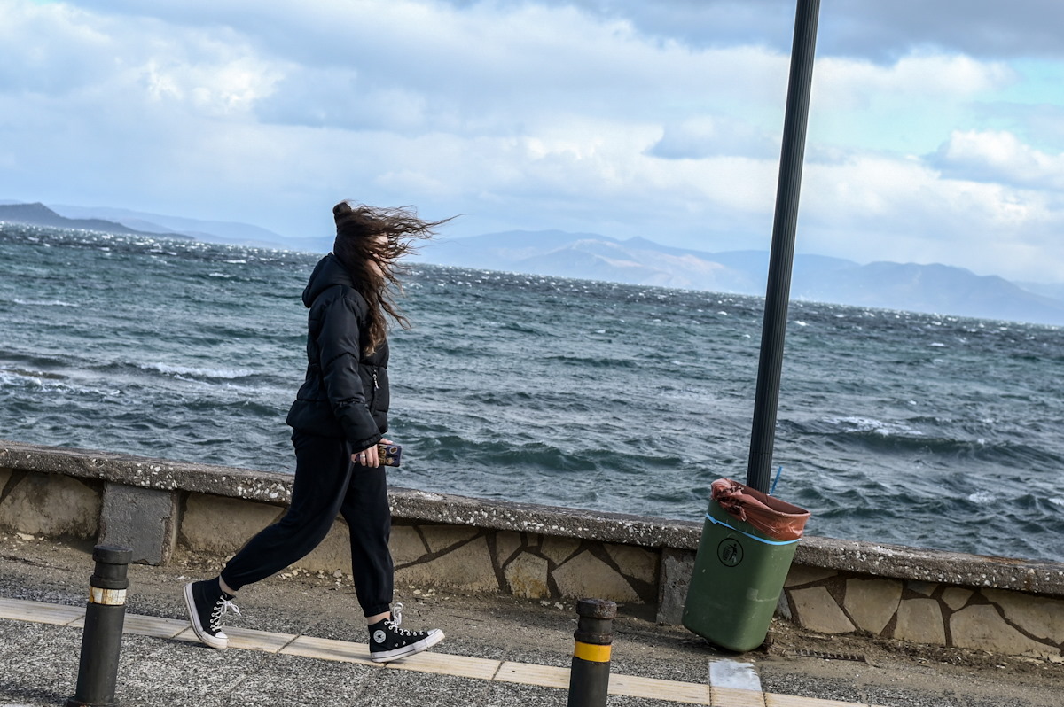 Μία κοπέλα περπατάει δίπλα από τη θάλασσα