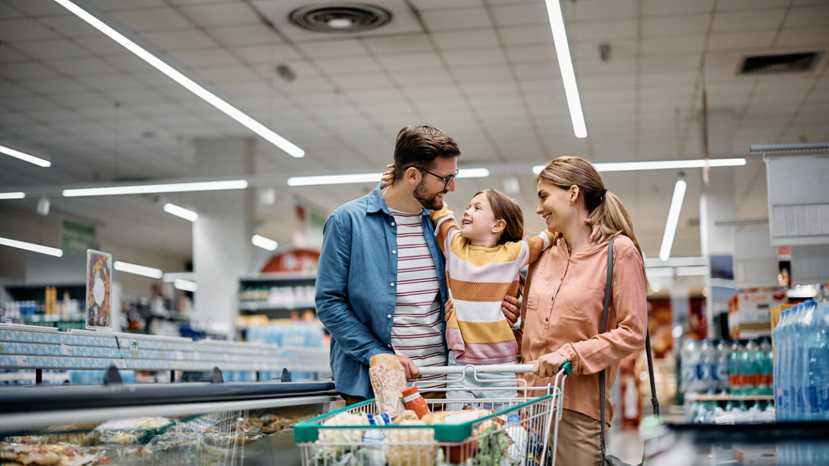 Happy embraced family enjoying in shopping at supermarket.