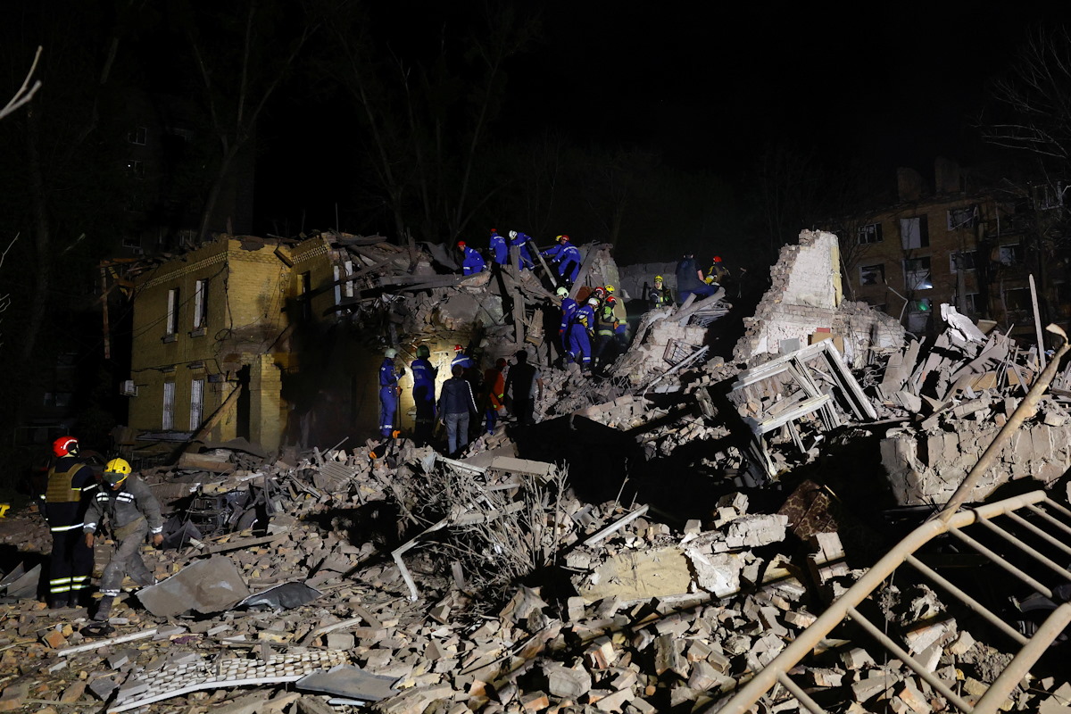 Οι διασώστες εργάζονται στον χώρο πολυκατοικίας που χτυπήθηκε από ρωσικό βαλλιστικό πύραυλο, εν μέσω της επίθεσης της Ρωσίας στην Ουκρανία, στο Κίεβο