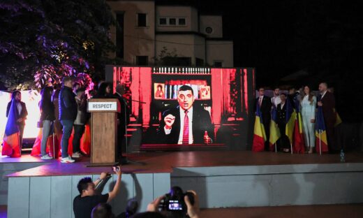 Υποστηρικτές του  George Simion παρακολουθούν τον ίδιο να μιλάει σε γιγαντοοθόνη - ΦΩΤΟ REUTERS