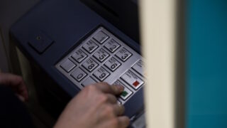 Μία γυναίκα χρησιμοποιεί ένα ΑΤΜ