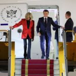 Το ζεύγος Μπριζίτ και Εμμανουέλ Μακρόν κατά την αποβίβασή τους από το αεροσκάφος, δευτερόλεοπτα μετά το χαστούκι