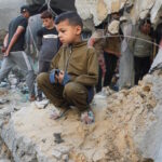 Ένα αγόρι από την Παλαιστίνη κοιτάζει δίπλα στις ζημιές που προκλήθηκαν από ισραηλινό χτύπημα σε σπίτι, στην Τζαμπάλια, στη βόρεια Λωρίδα της Γάζας