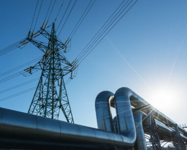 Industrial pipelines on pipe-bridge against blue sky