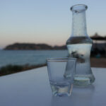 Raki is a sweetened, often anise-flavoured, alcoholic drink that is popular in Albania, Turkic countries, Turkey, Greek Islands and in the Balkan countries as an apéritif. It is often served with seafood or meze. It is comparable to several other alcoholic beverages available around the Mediterranean and the Middle East, e.g. pastis, ouzo, sambuca, arak and aguardiente. In Crete tsikoudia is a pomace brandy that is sometimes called rakı but made from grapes. It is used to make rakomelo, which is flavored with honey and cinnamon. Rakomelo is served warm during winter months.