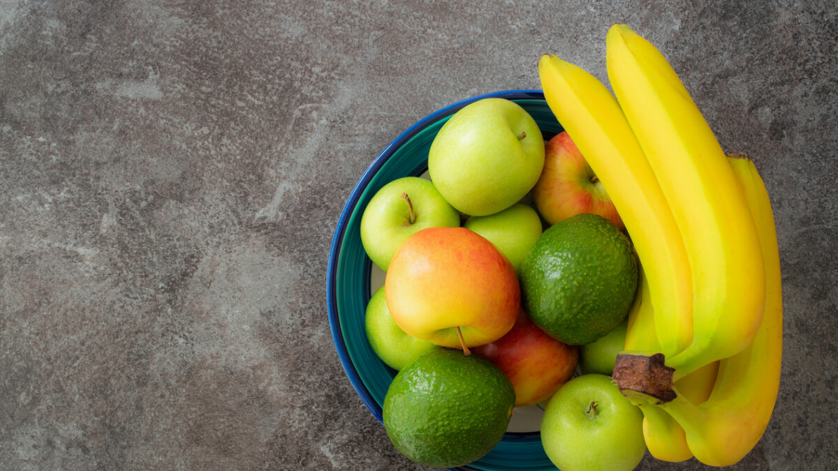 directly above shot of healthy fruits in pottery bowl on stone kitchen counter