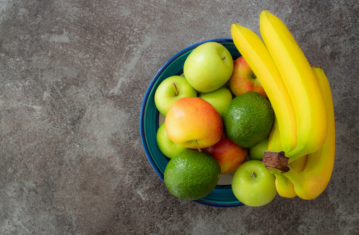 directly above shot of healthy fruits in pottery bowl on stone kitchen counter
