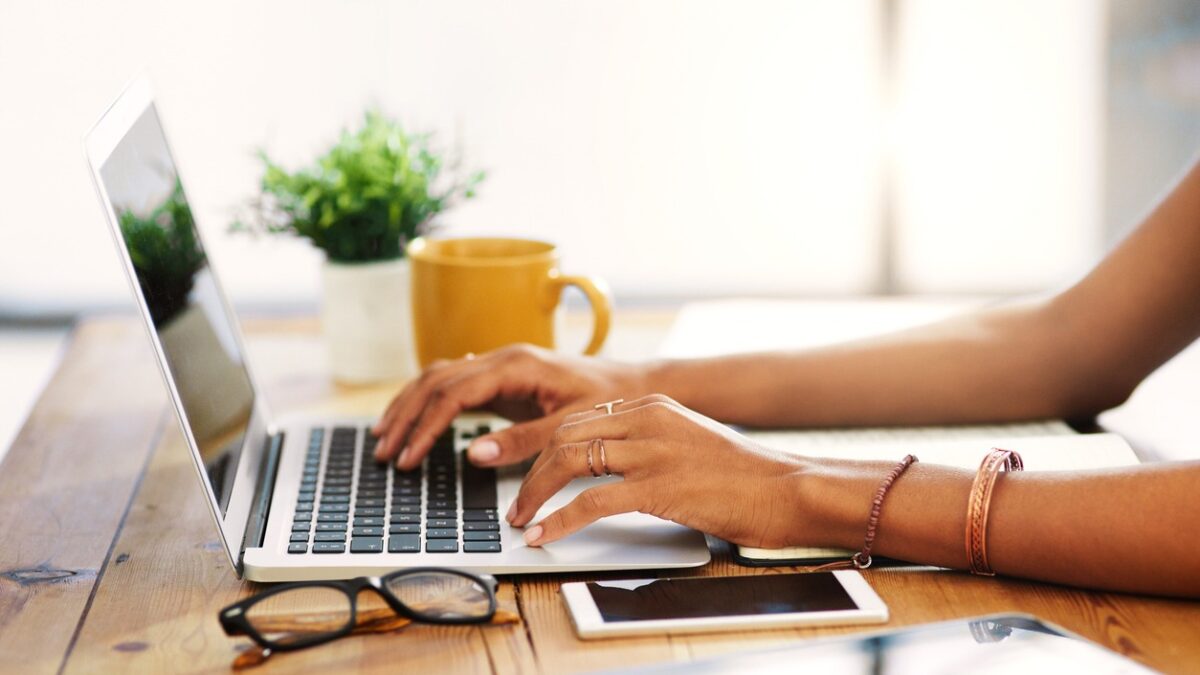 Cropped shot of an unrecognizable businesswoman sitting alone and typing on her laptop during the day at home