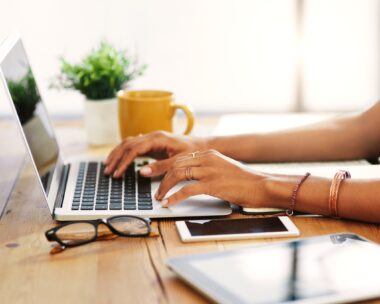 Cropped shot of an unrecognizable businesswoman sitting alone and typing on her laptop during the day at home