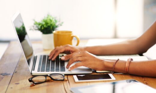 Cropped shot of an unrecognizable businesswoman sitting alone and typing on her laptop during the day at home
