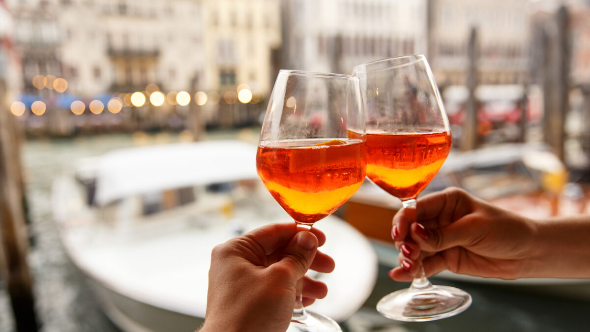Couple clinking glasses with Spritz in Venice, Italy