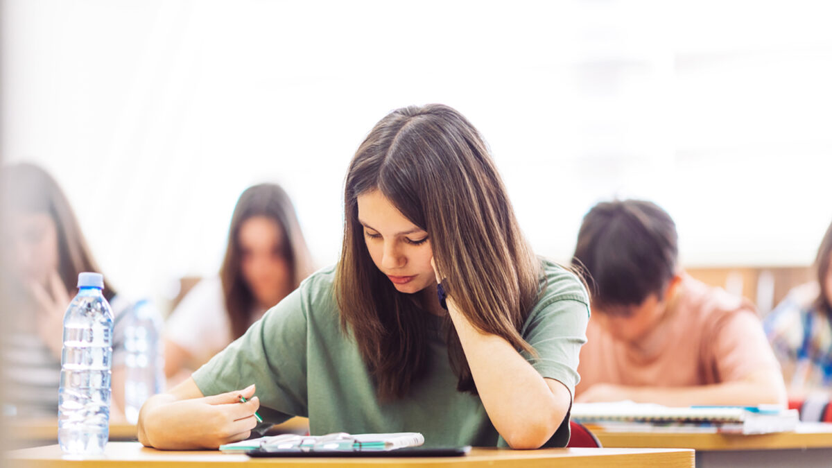 Teenage students sitting in school's classroom and learning. They are using tablet and studying with good concentration in their modern school.