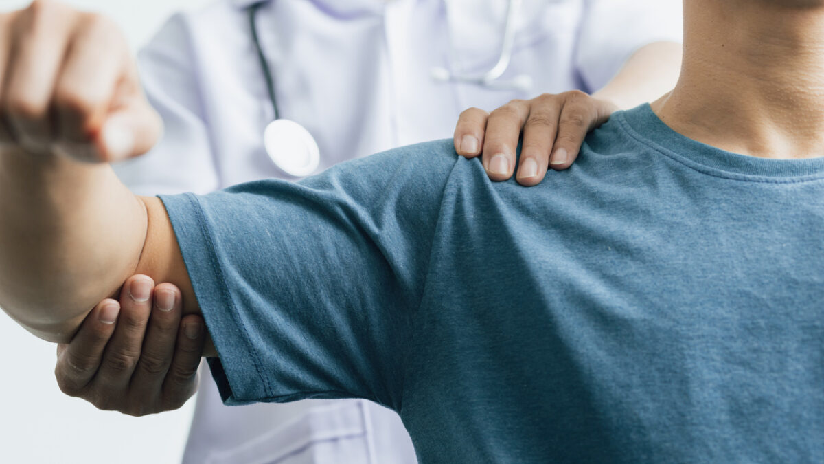 A man with shoulder pain goes to the doctor, The doctor diagnoses the patient's arm pain and shoulder pain. Concept of physical therapy and rehabilitation.