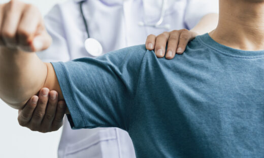 A man with shoulder pain goes to the doctor, The doctor diagnoses the patient's arm pain and shoulder pain. Concept of physical therapy and rehabilitation.