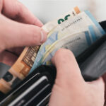 close-up view of hands taking money out of a wallet